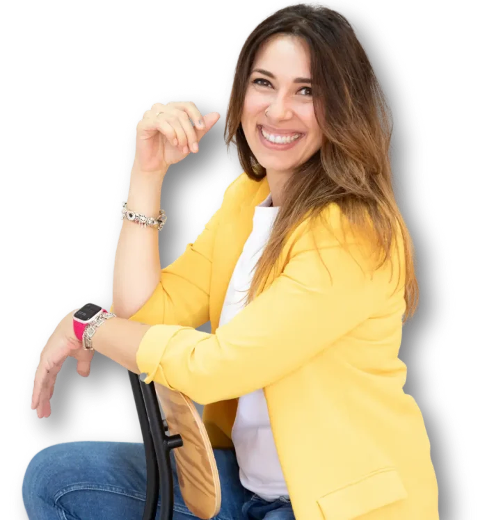 Laura G.Arias, sentada y sonriendo, con americana amarilla
